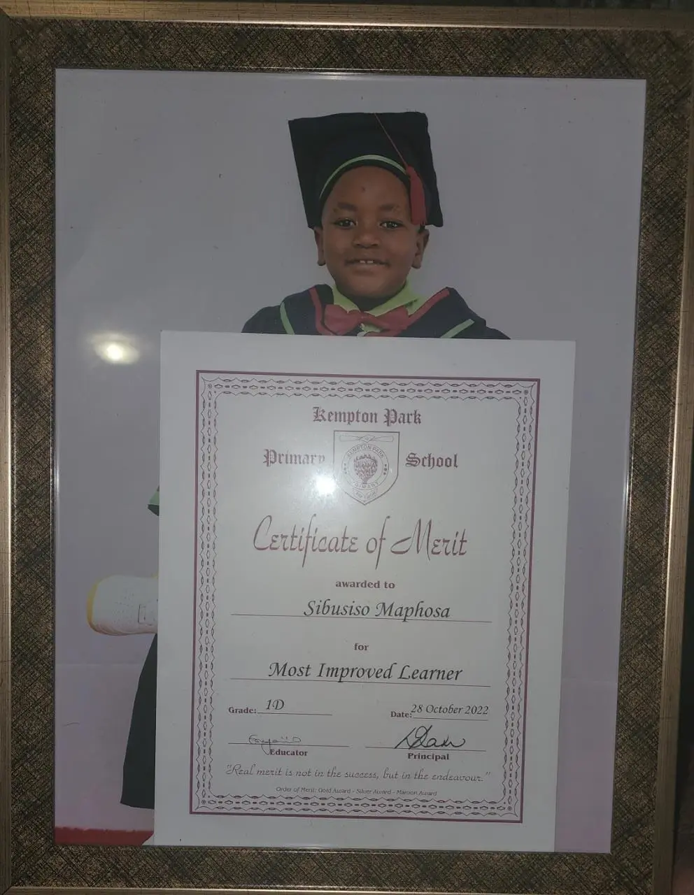 Day care leaner in graduation gown holding a graduation certificate